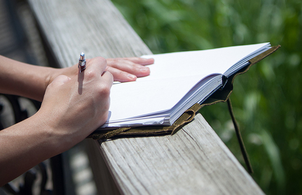 Woman writing in gratitude journal