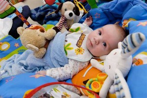 Baby surrounded by toys - creating community: interdependence